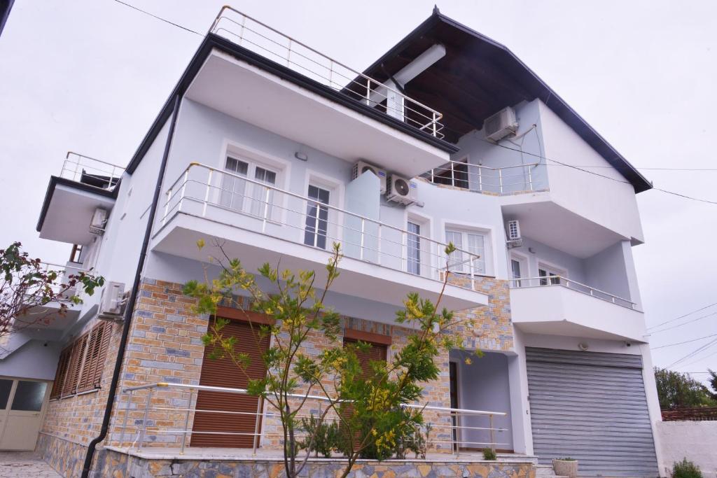a white apartment building with a balcony at Guest House Vila Krejs in Durrës