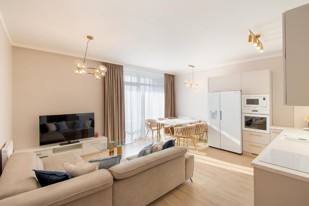 a living room with a couch and a kitchen at Aparts Care Beztroski Apartament Ku Morzu in Sianozety