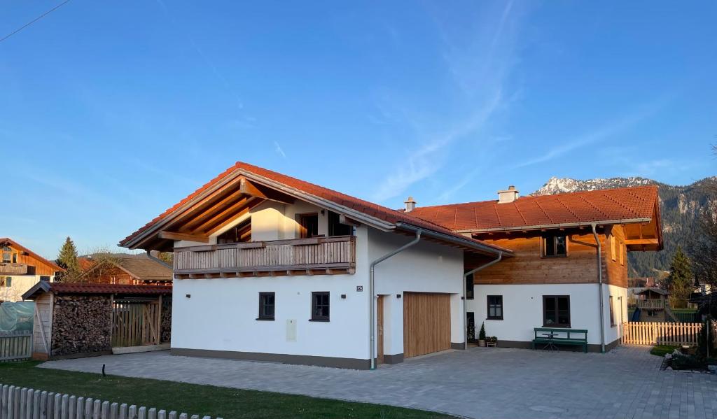 a large white house with a wooden roof at Ferienwohnung Kirmaier in Schwangau