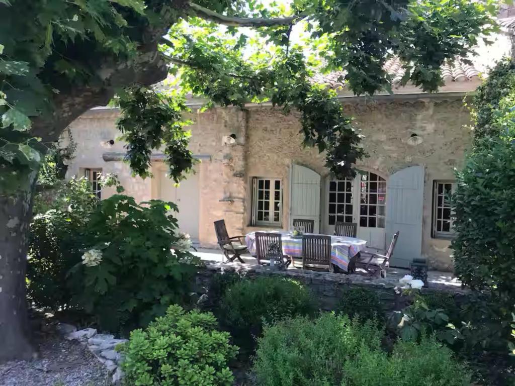 une maison avec une table et des chaises devant dans l'établissement MAS PILY, à Saint-Rémy-de-Provence