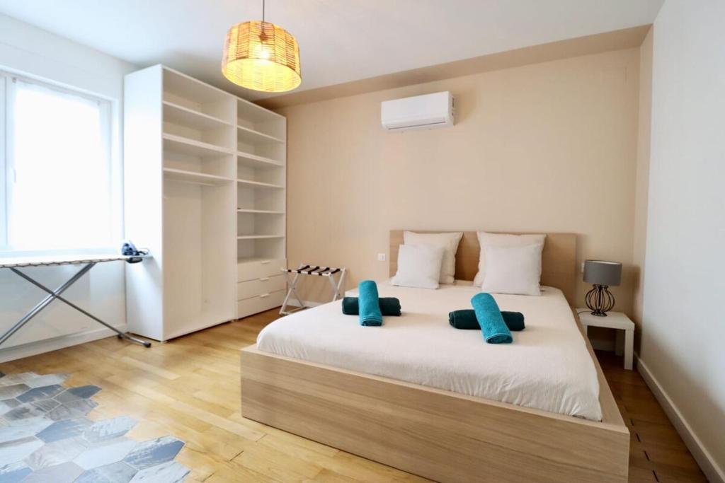 a bedroom with a large white bed with blue pillows at Génial T4 90m2 cosy&clim 3 CHB 2 SDB - tram 5min du centre de Strasbourg in Strasbourg