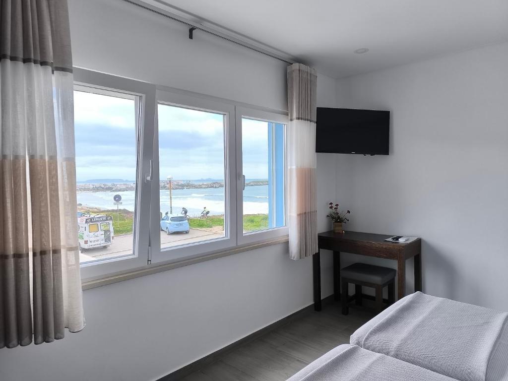 a bedroom with a window with a view of the ocean at Baleal 4 Surf II in Baleal