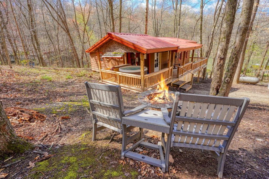 a log cabin with a table and two chairs and a fire at Wyandot Woods - Firefly in Laurelville
