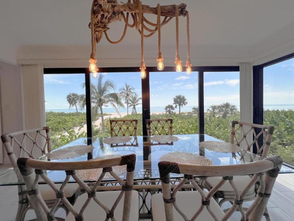 a dining room with a glass table and chairs at Kings Crown 118 in Sanibel