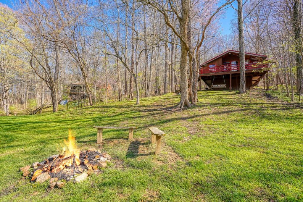 a fire pit in the grass next to a cabin at Wyandot Woods - Squirrels Nest in Laurelville