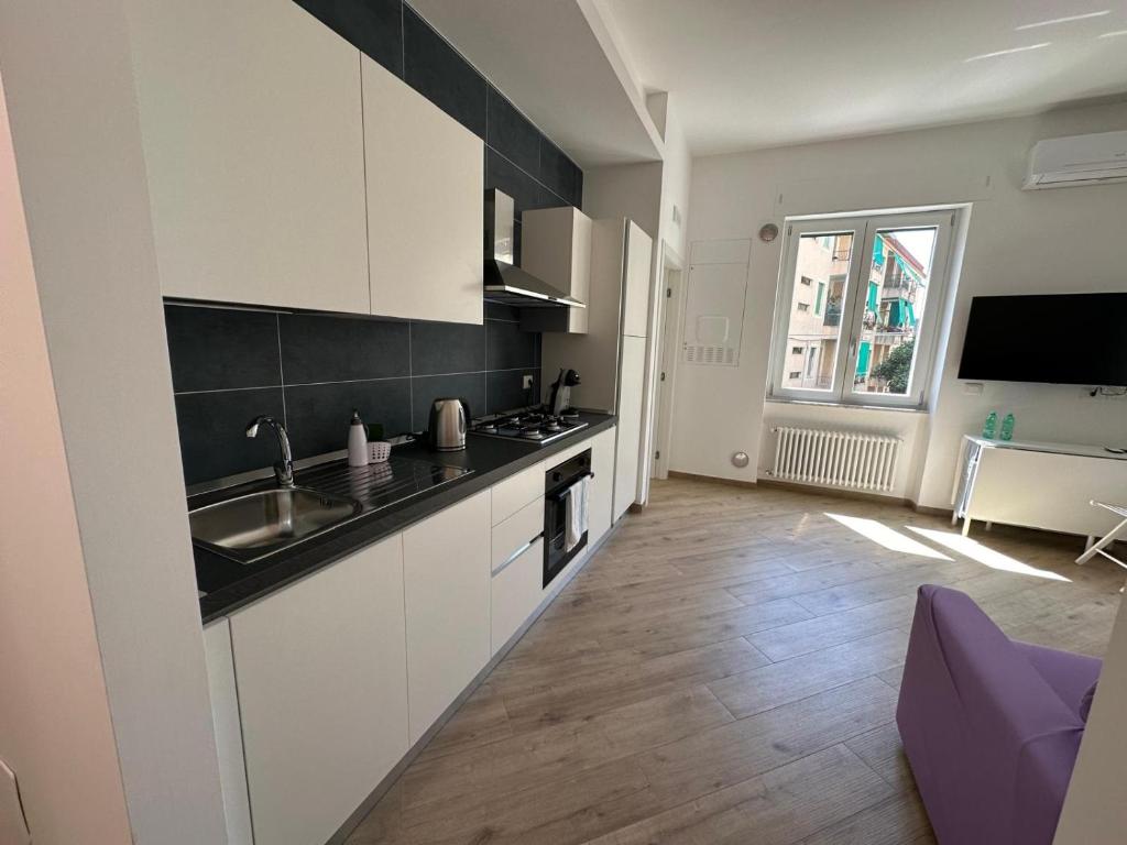 een keuken met witte kasten en een spoelbak bij Casa Bavosa via Cacciatore in Salerno