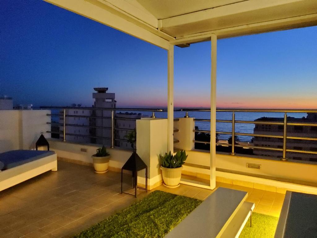 a balcony with a view of the ocean at night at Seven Sky Penthouse in Sousse