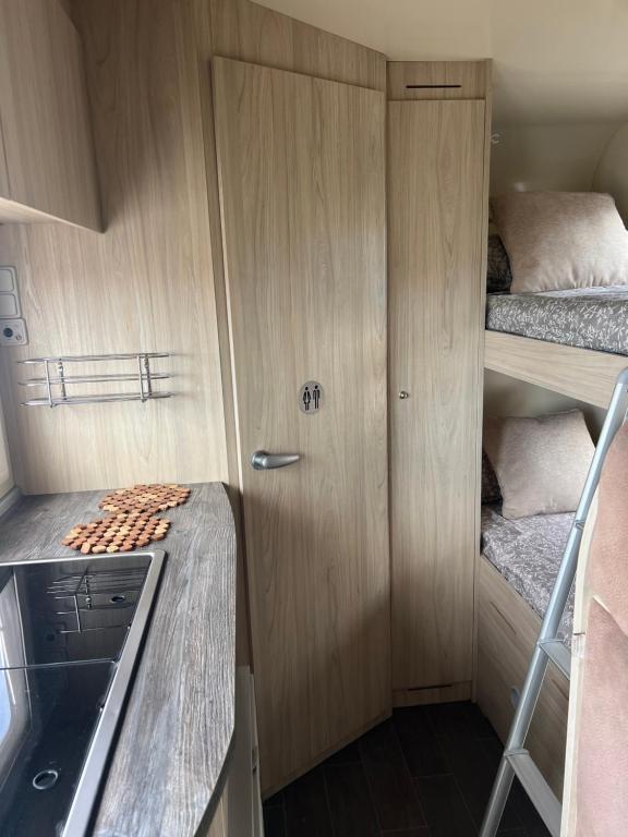 a kitchen with wooden cabinets and a counter top at Kuaycaravans in Adeje