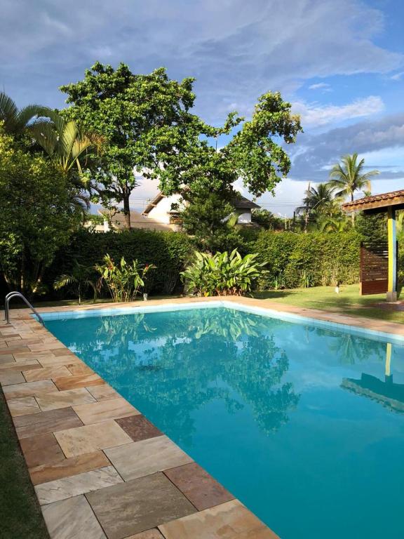 a swimming pool with blue water in a resort at Pousada 4 Elementos Guaruja in Guarujá