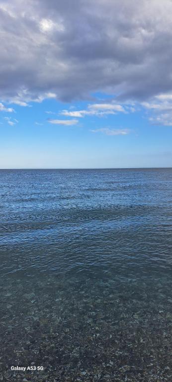 duży zbiornik wodny z zachmurzonym niebem nad nim w obiekcie Casa Holiday Sea Etna Di Enza w mieście Linguaglossa