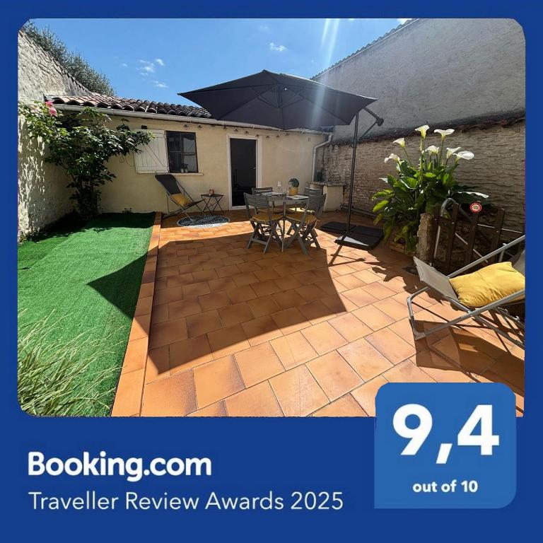 un patio avec une table et un parasol dans l'établissement Charmante maison avec cour privative, à Cognac