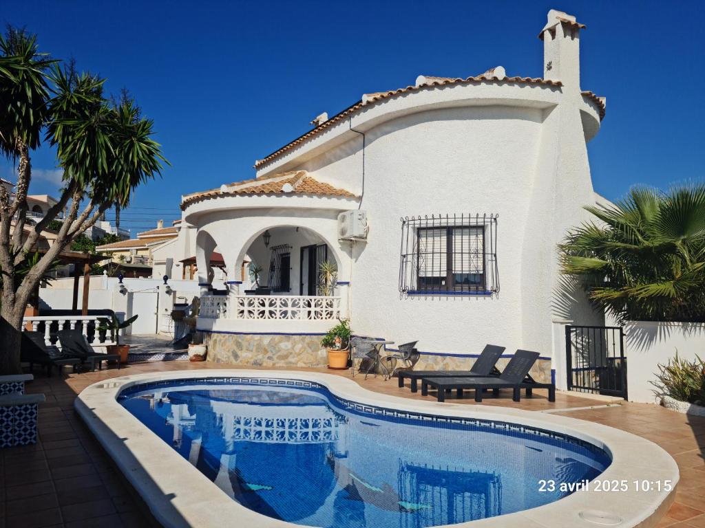 a villa with a swimming pool in front of a house at casa des loups in Ciudad Quesada