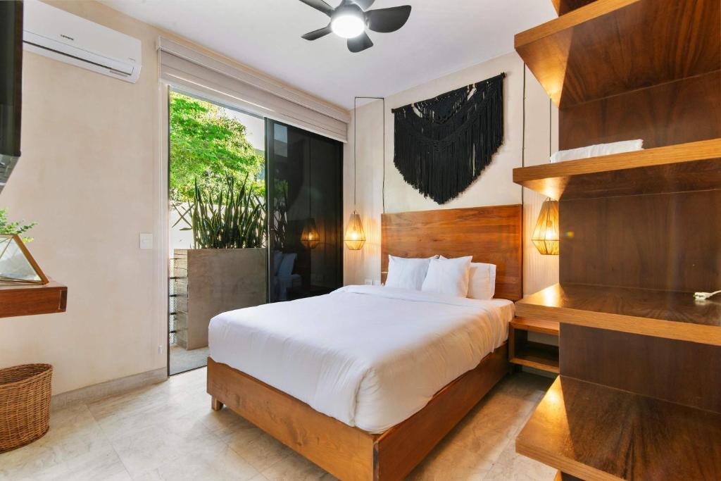 una camera da letto con un letto e una grande finestra di 2-BR Aldea Zama Sanctuary of Tulum a Tulum