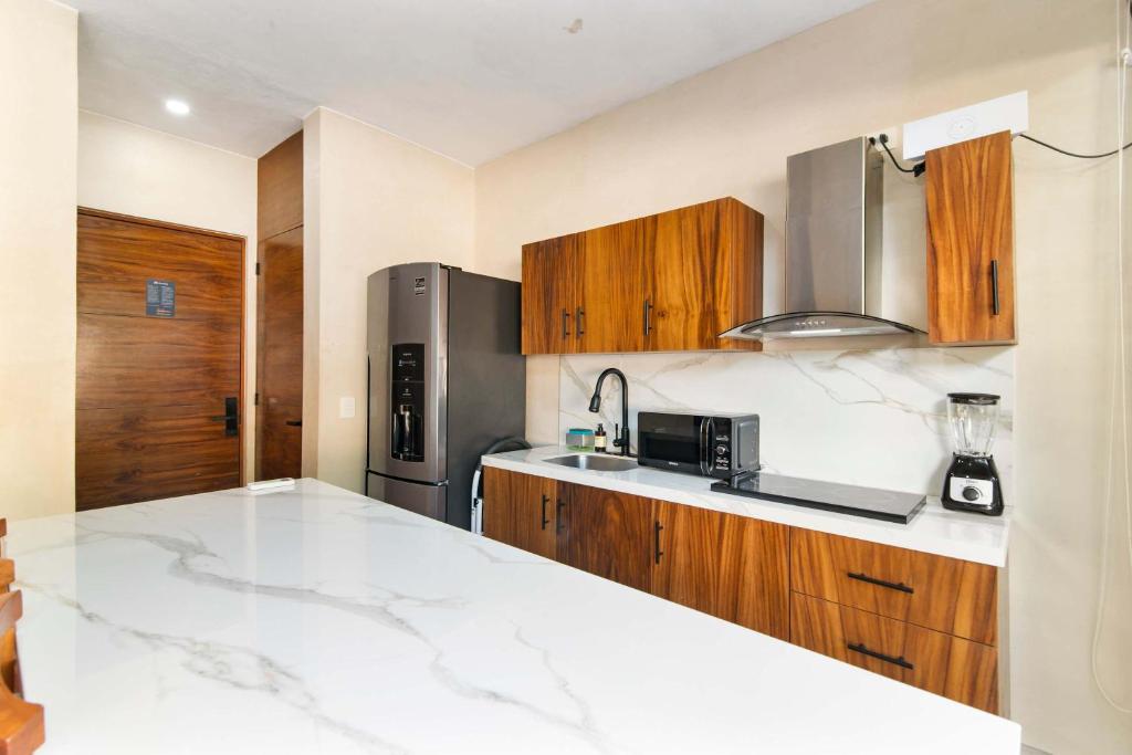 una cucina con armadi in legno e frigorifero in acciaio inossidabile di 2-BR Aldea Zama Sanctuary of Tulum a Tulum