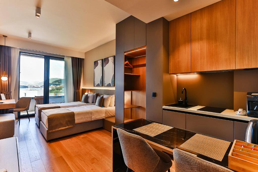a hotel room with a bed and a dining room at Regent Resort Budva in Budva
