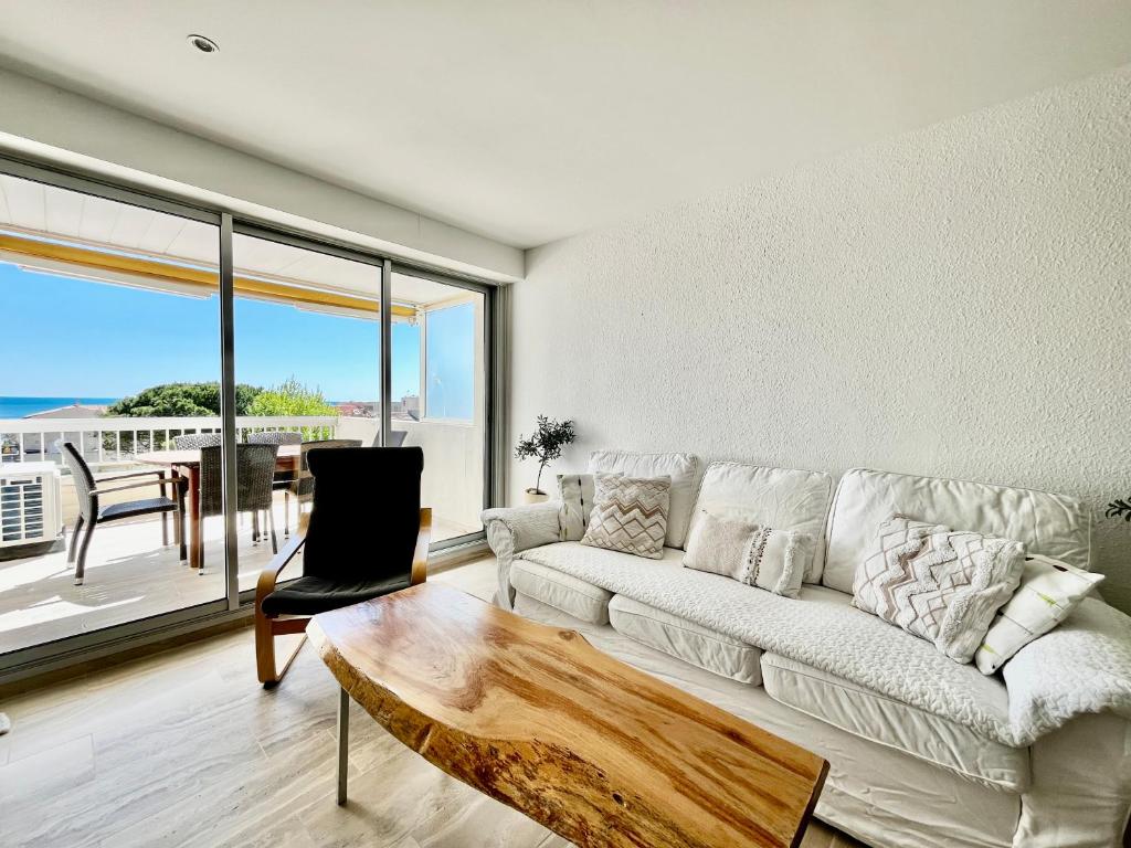 un salon avec un canapé blanc et une table dans l'établissement Entre Mer & Port - T3 Carnon, Terrasse, Clim, à Mauguio