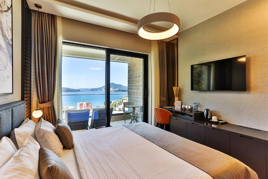 a bedroom with a large bed with a large window at Regent Resort Budva in Budva