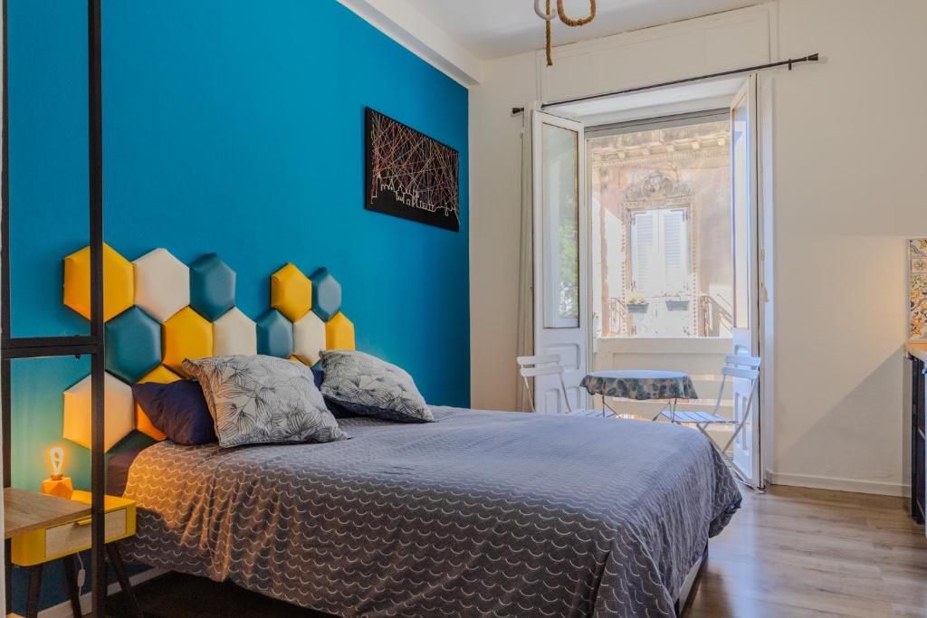 a bedroom with a blue wall and a bed at Casa Remy in Cagliari