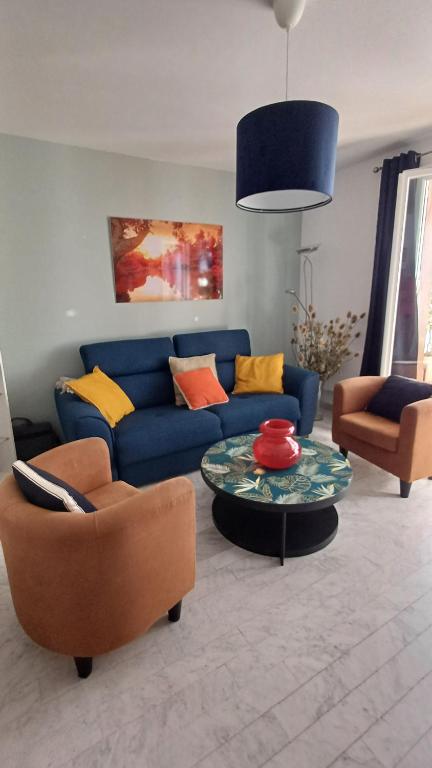 un salon avec un canapé bleu et deux chaises dans l'établissement Lumière, à La Ciotat