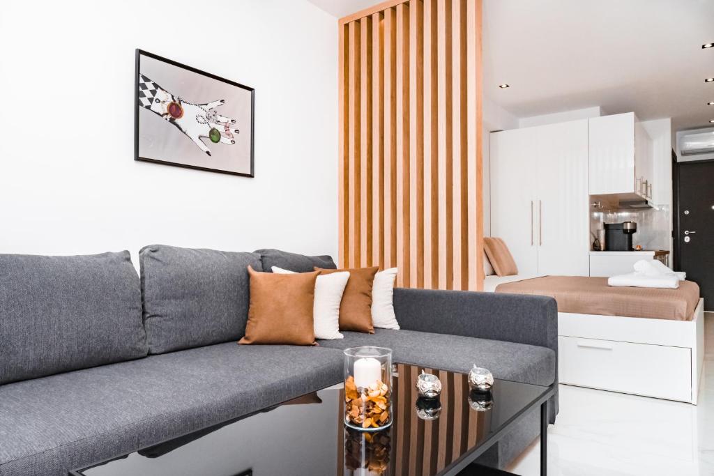 a living room with a gray couch and a table at Studio D1 in Kallithea Halkidikis