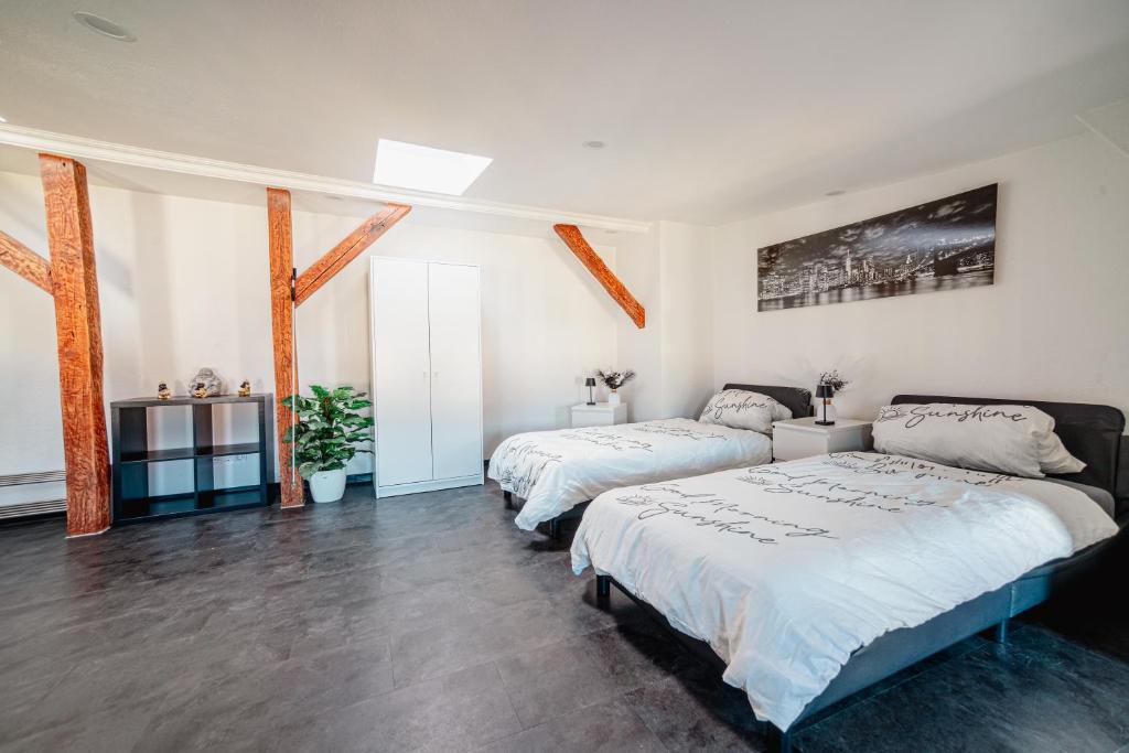 twee bedden in een kamer met witte muren en houten vloeren bij Moderner Altbau für 3 in Maagdenburg