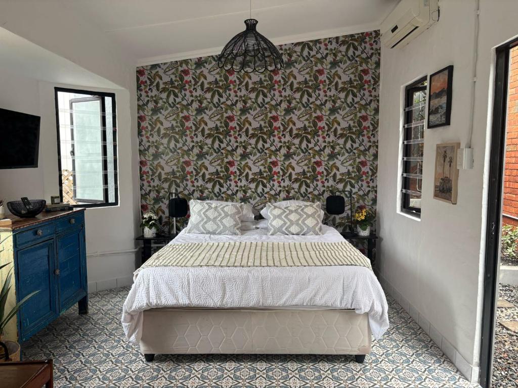 a bedroom with a bed and a floral wall at Studio at 142 in Durban