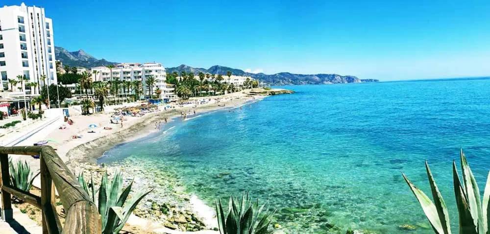 Una vista de una playa con gente y el océano. en 2 minutes from the beach!!! Great apartment!!!, en Nerja