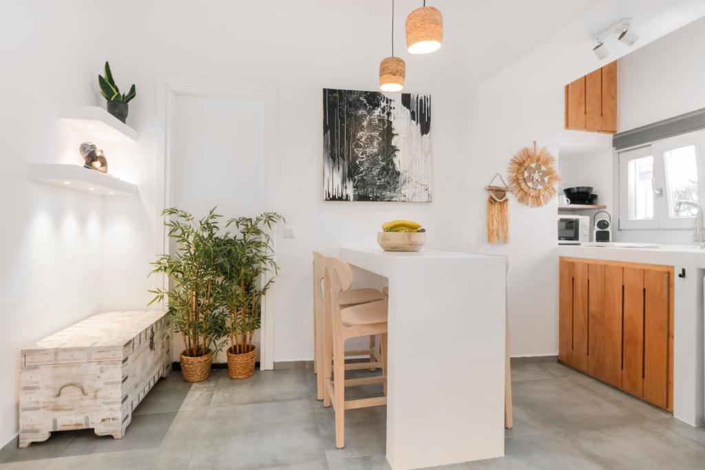 een keuken met witte muren en een aanrecht met planten bij August Mykonos in Mykonos-stad