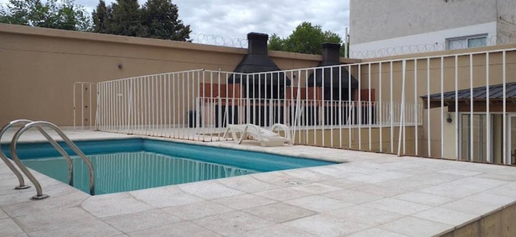een zwembad voor een hek bij Carriles Inn in Mendoza