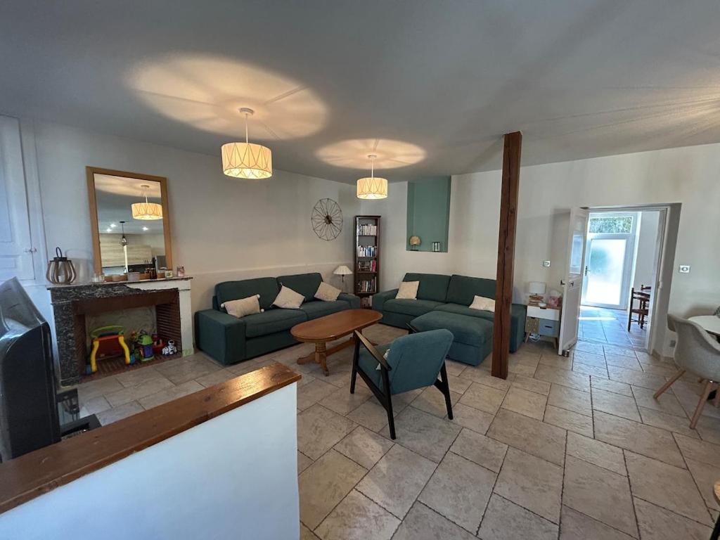 a living room with a couch and a fireplace at Maison de ville, Gien centre in Gien