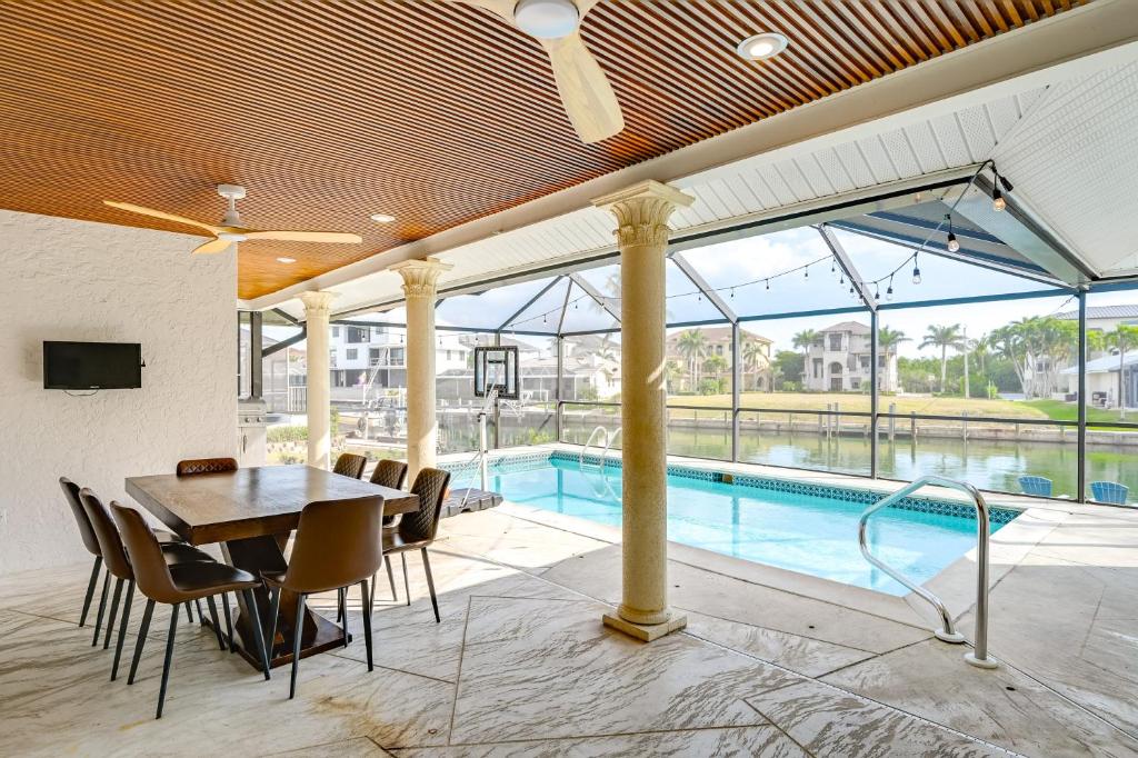 Walk to Tigertail Beach! Marco Island Home with Pool في جزيرة ماركو: غرفة طعام مع طاولة ومسبح