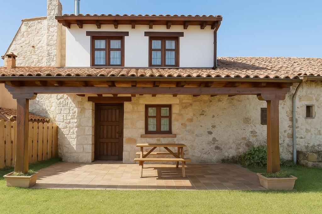 a picnic table in front of a house at El Jardín de Casa Male in Pimiango