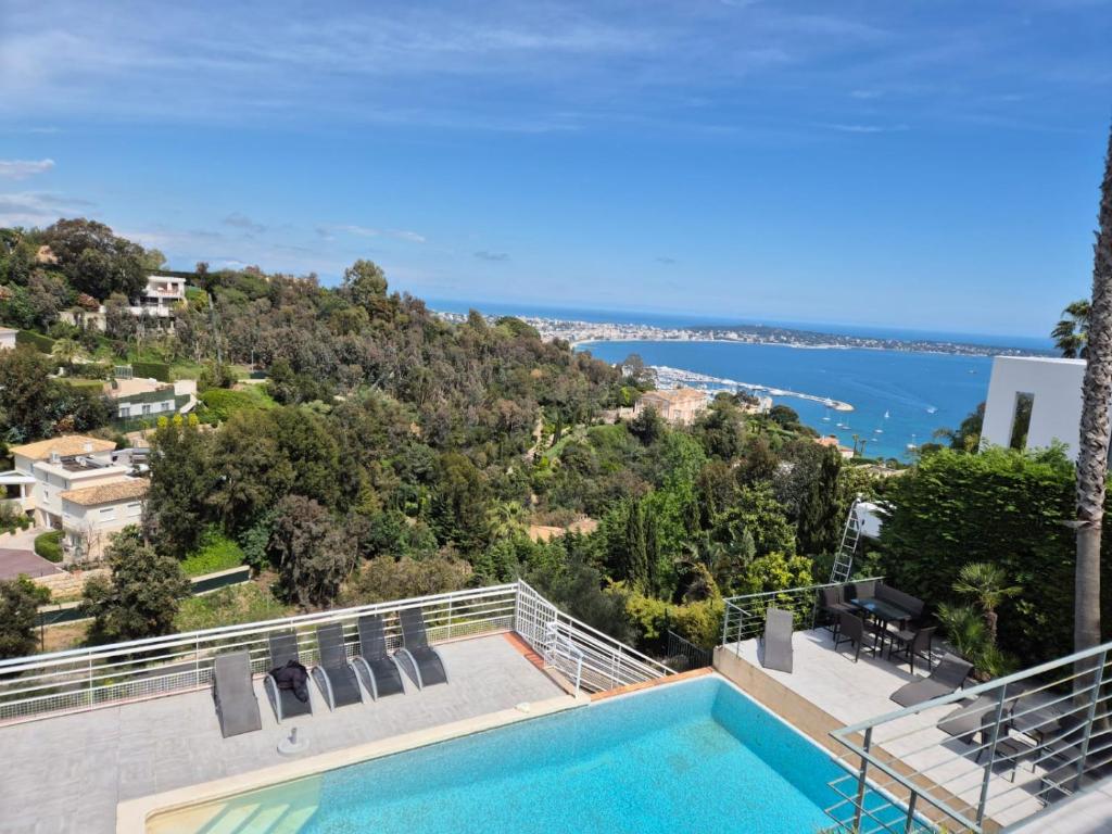 une vue d'une piscine depuis une maison dans l'établissement Cannes Super Cannes Golfe-Juan - Vue mer exceptionnelle méditerranée Cap d'Antibes- Villa Alamp - 4 à 6 chambres 6 sdb 7 wc - piscine - Superbe rooftop sans vis-à-vis - grand living - Possibilité Courts séjours -, à Vallauris