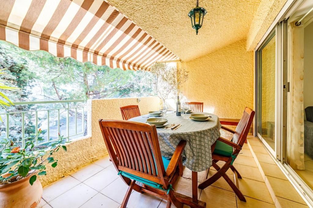 une salle à manger avec une table et des chaises sur un balcon dans l'établissement A Deux pas de la Mer, à Bandol