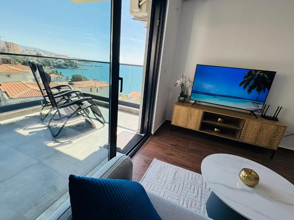 ein Wohnzimmer mit einem TV und einem großen Fenster in der Unterkunft Mellas Premium Apartment in Dobra Voda