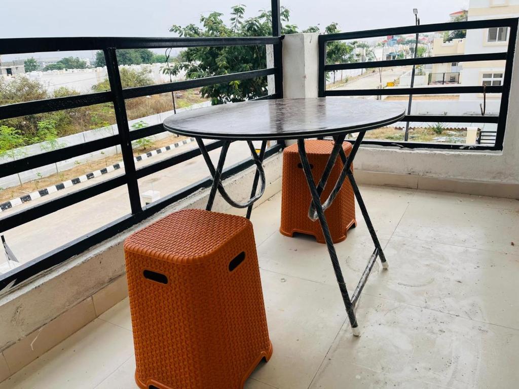 TurkapallyCorporate Hostel & PG的窗前的桌子和凳子