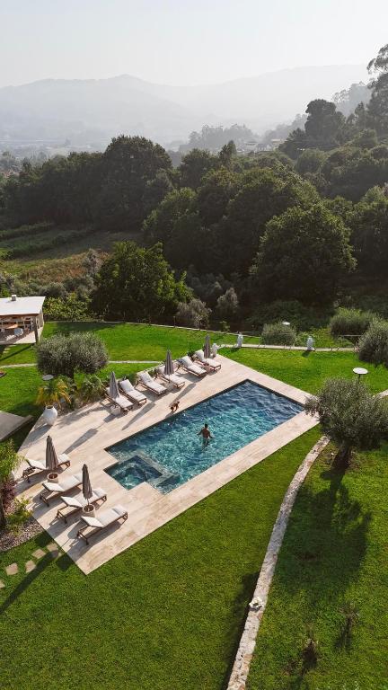 una piscina con sillas y una persona en el agua en Rosal Country Village, en Ponte de Lima