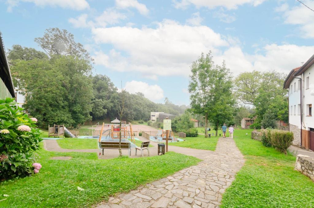 a garden with a playground in the distance at La casina in Porrúa
