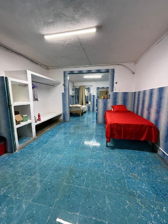 a bedroom with a red bed and a blue floor at CasaAZUL in Progreso