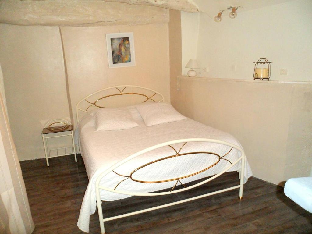 a bedroom with a large bed with white sheets at apartement des Romains in Sospel