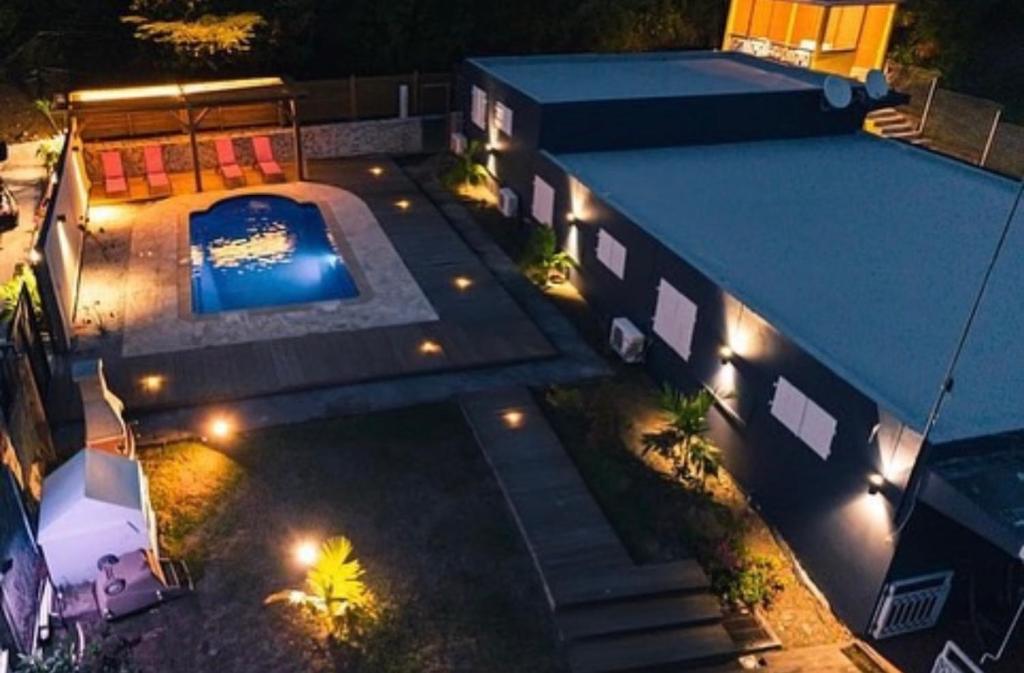 an overhead view of a house with a swimming pool at night at Domaine Yacinthe in Le Robert