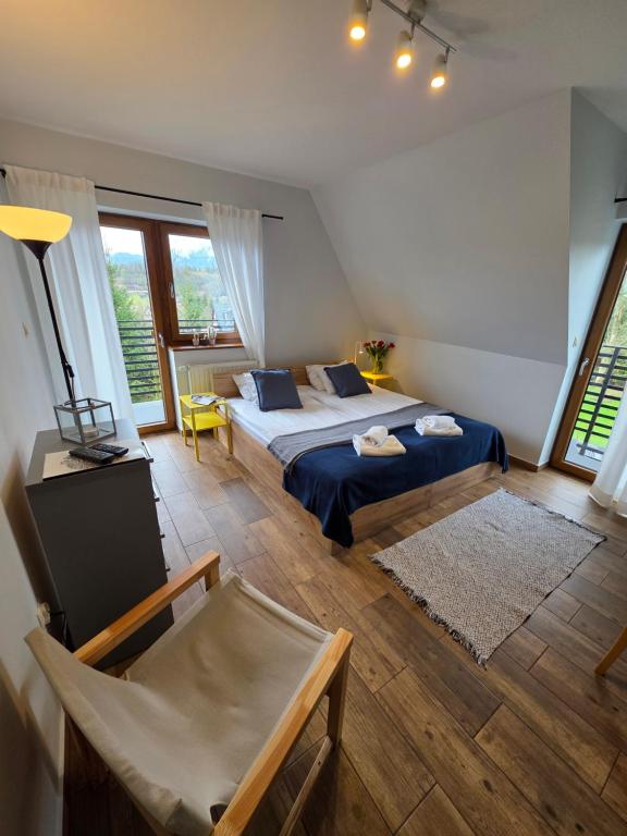 a bedroom with two beds and a chair in it at U Suchowiana - cisza i spokój z widokiem na Tatry in Zakopane