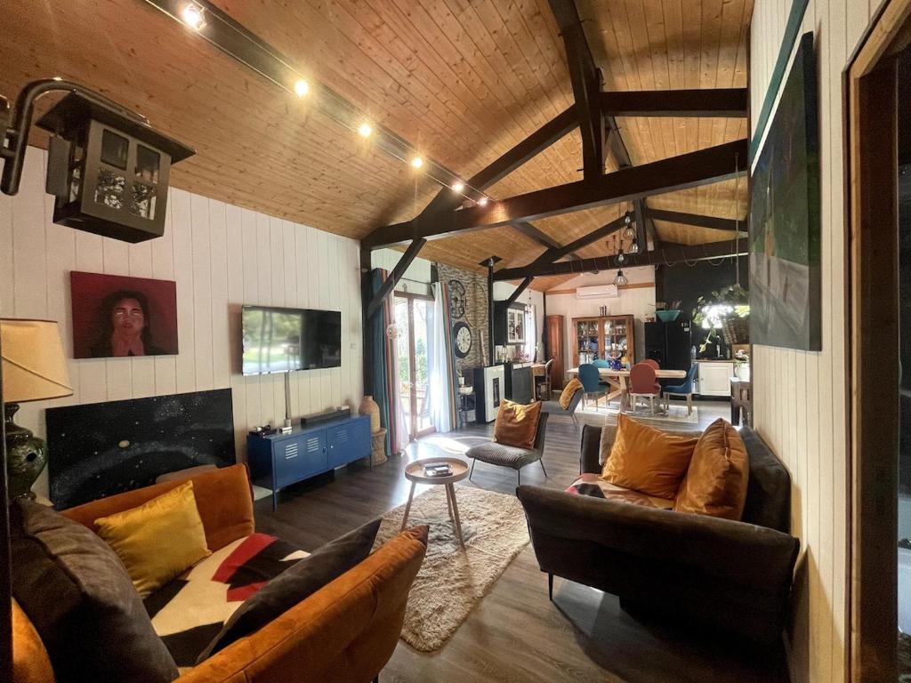 un grand salon avec des canapés et une cheminée dans l'établissement La grange sous les pins landais, à Pissos