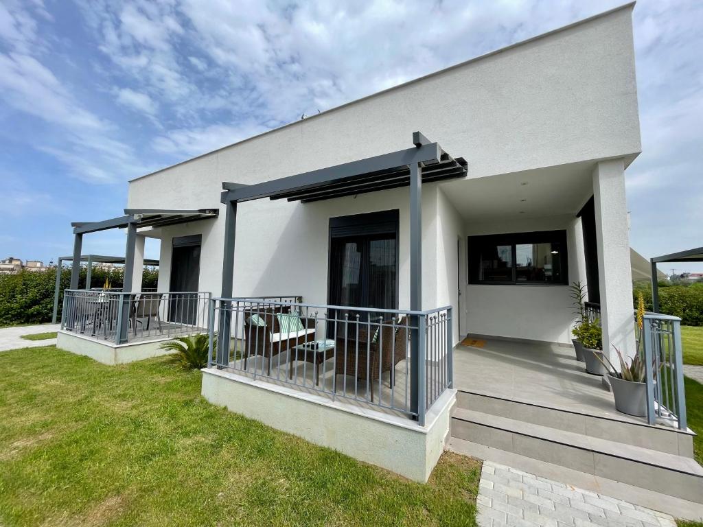 a white house with a balcony and grass at Neo-Residence in Neochórion