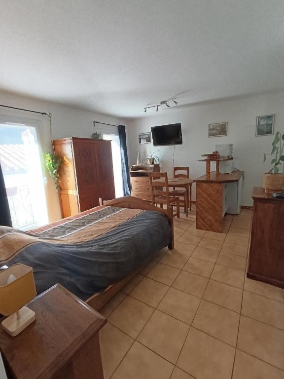 une chambre avec un lit et une table et une cuisine dans l'établissement Studio cosy tout confort, à Amélie-les-Bains-Palalda