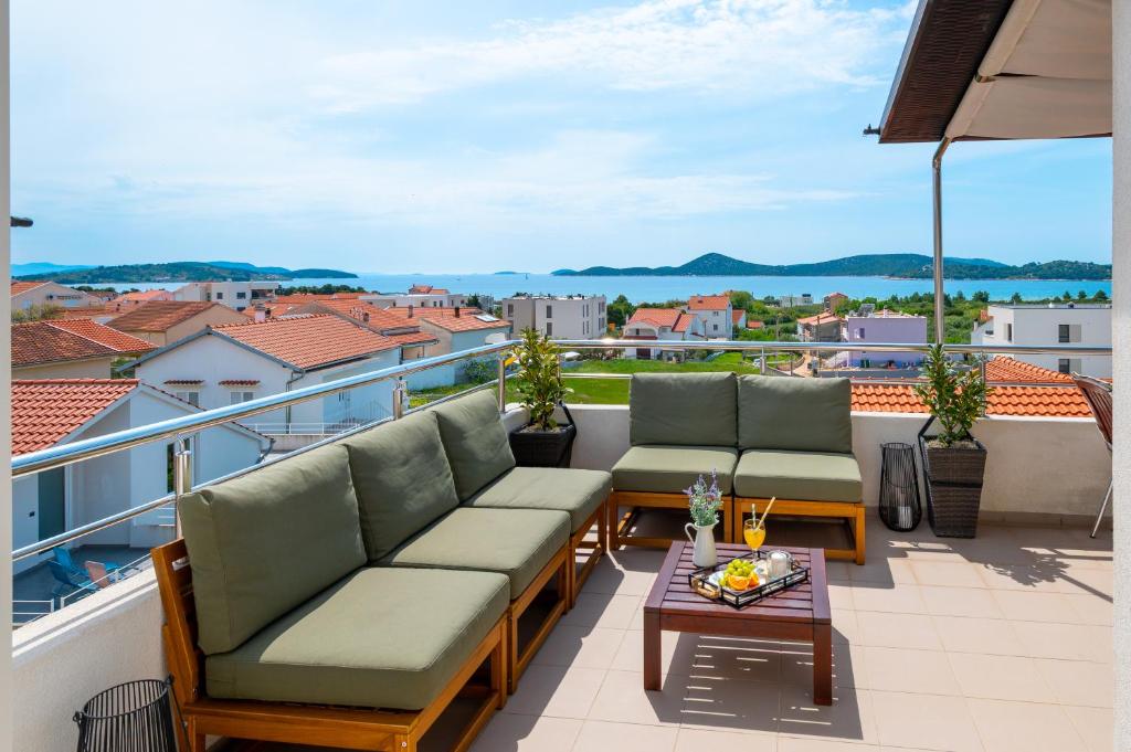 a balcony with couches and a table with a view at Seaview Apartments Tihi in Vodice
