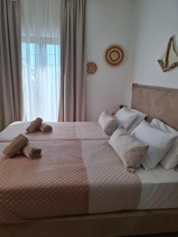 a bedroom with a large bed with pillows and a window at Mariza Apartments -studios in Hanioti