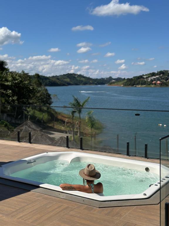 a person in a jacuzzi tub with a hat at Surreal Igaratá Pousada in Igaratá