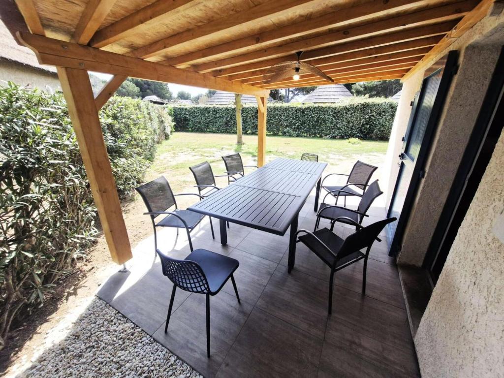 un patio avec une table et des chaises sur une terrasse dans l'établissement Résidence Ile Des Pecheurs - VILLA 3 PIECES 6 couchages LE BARCARES MAE-6674, à Port-Leucate