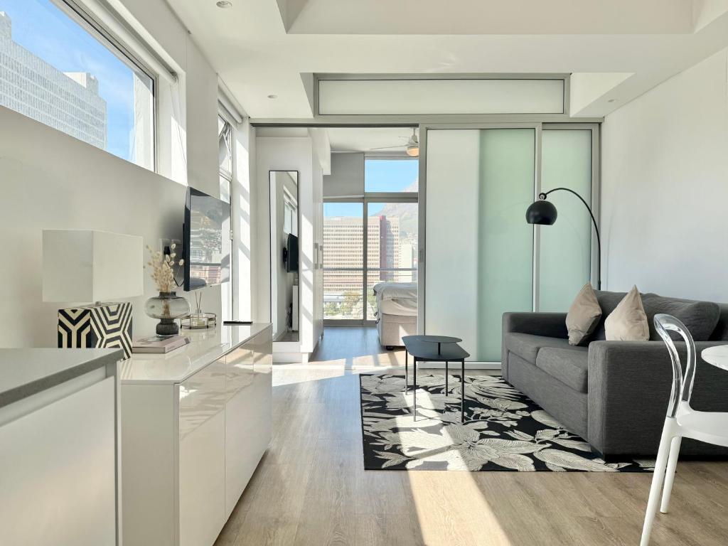 a living room with a couch and a table at Studio corner unit in the heart of CBD in Cape Town